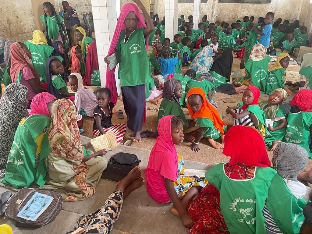 Jeunes filles assises au sol avec leurs Corans pendant un cours dans un daara à Touba